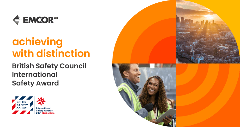 EMCOR UK highlighting their two International Safety Awards - accompanying image of city skyline and two EMCOR UK workers in safety gear smiling.